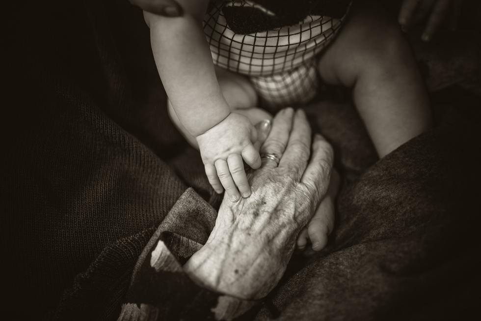 A baby's hand on an elderly person's hand