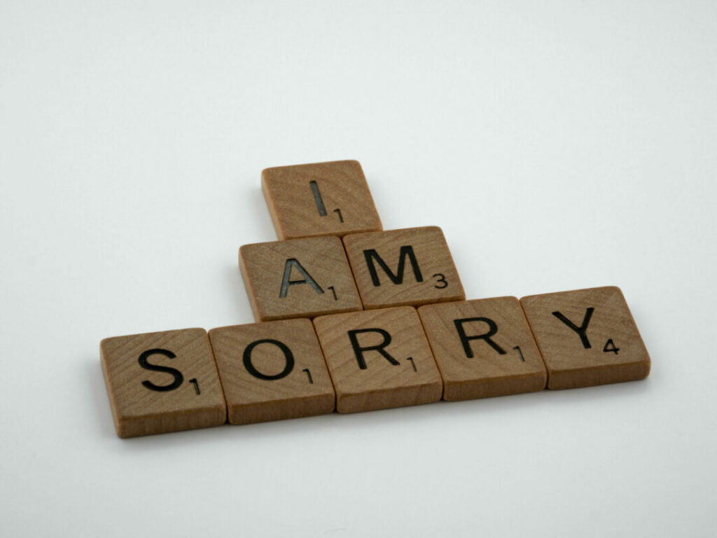Scrabble game pieces spelling out the phrase "I AM SORRY"